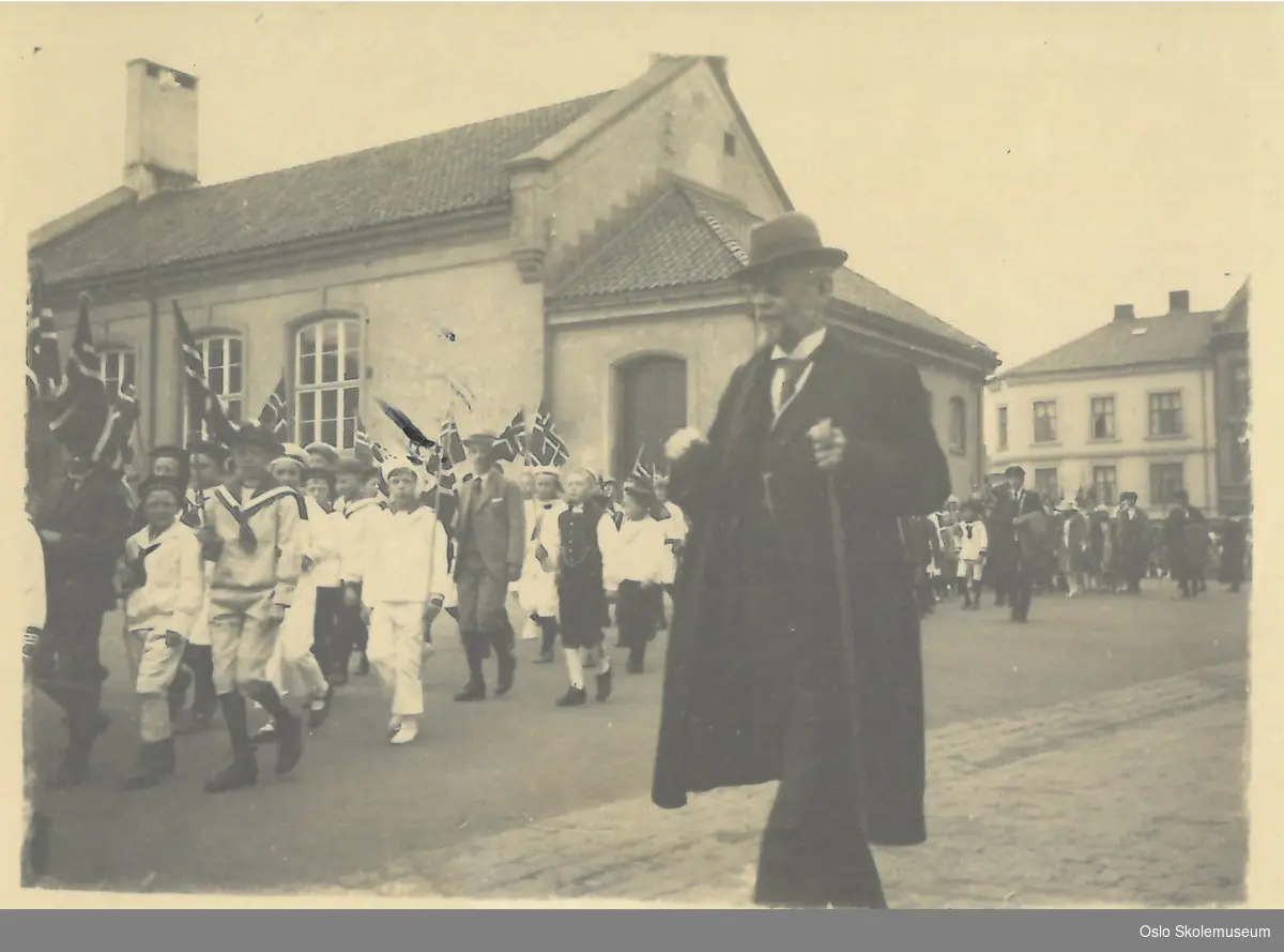 Overlærer Anton Wildhagen går ved siden av et barnetog på 17. mai i 1922.