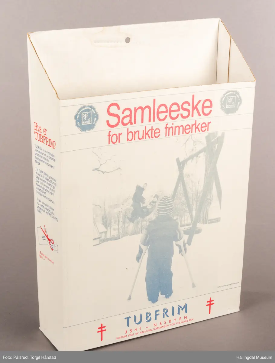En hvit pappeskemed åpen topp. Bakplaten er høyere enn fronten, sidene skrår litt ned mot fronten. På fronten er det trykt på skrift: "Samleeske for brukte frimerker". Under et bilde at et barn med krykker forran et huskestativ står teksten: "TUBFRIM 3541 - Nesbyen. Tubfrim eies av Nasjonalforeningen for folkehelsen". I tillegg er det plassert små blå poststempler i de øverste hjørnene, en i hver. På hver side at den nederste teksten er det et rødt Lothringenkors, eller dobbeltkors. På den ene kostsiden står det en tekst i blå font med rød overskrift om hva Tubfrim er, stående over en illustrasjon av en rød saks som klipper bort et frimerke fra en konvolutt. Under står det "-Esken bes brukt om igjen ...". På den andre kortsiden står det en lengre tekst i blå font med rød oversikrift om hvordan eksen bør brukes, stående over den samme illustrasjonen med saks og konvolutt. Under dette står: "TUBFRIM N-3541 Norge. Tlf. 067-71094". 