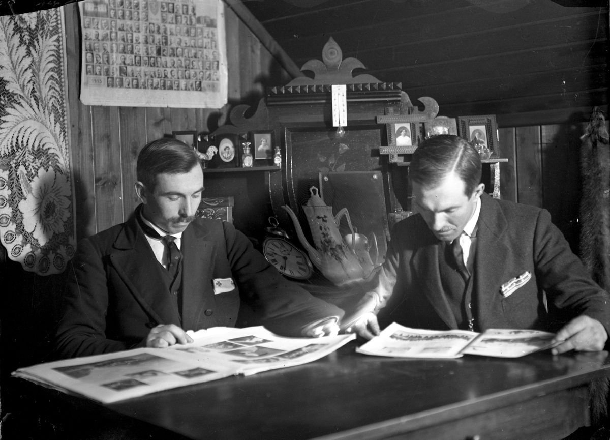 Portrett av to mann som leser, fotografiet er antakelig tatt i eller rett etter 
1913. Interiøret skildrer møbler med fotografier.

Ole Romsdalen til venstre

Fotosamling etter fotograf og skogsarbeider Ole Romsdalen (f. 23.02.1893).