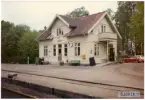 Västergötland - Göteborgs Järnväg, VGJ, Trafikplats anlagd 1899. Stationshus i en och en halv våning i trä. Moderniserad 1939 och renoverad 1949. Bil MG 1100.