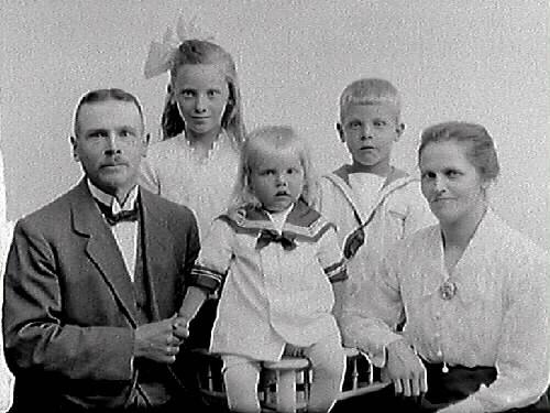 Edvin Andersson med fru Ida, sönerna Evert och den yngre Bertil samt dottern Märta. I fotografens liggare är Millbergska huset angivet, vilket sannolikt var familjens adress vid tiden. Charkuteriarbetare Edvin Andersson och Ida Hagström gifte sig 1910 i Missionskyrkan i Varberg (se bildnr MR2_1097). Edvin hade flyttat till Varberg 1905 och arbetade även som vaktmästare i Missionskyrkan fram till 1916, då familjen flyttade till Tvååker. De återvände till Varberg 1919. Han hade många uppdrag i församlingen som söndagsskollärare, ledamot i församlingsstyrelsen etc. (Se även bildnr GB3_17515 på barnen).