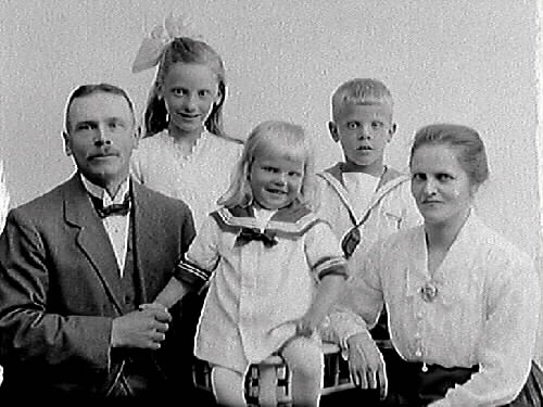 Edvin Andersson med fru Ida, sönerna Evert och den yngre Bertil samt dottern Märta. I fotografens liggare är Millbergska huset angivet, vilket sannolikt var familjens adress vid tiden. Charkuteriarbetare Edvin Andersson och Ida Hagström gifte sig 1910 i Missionskyrkan i Varberg (se bildnr MR2_1097). Edvin hade flyttat till Varberg 1905 och arbetade även som vaktmästare i Missionskyrkan fram till 1916, då familjen flyttade till Tvååker. De återvände till Varberg 1919. Han hade många uppdrag i församlingen som söndagsskollärare, ledamot i församlingsstyrelsen etc. (Se även bildnr GB3_17515 på barnen).