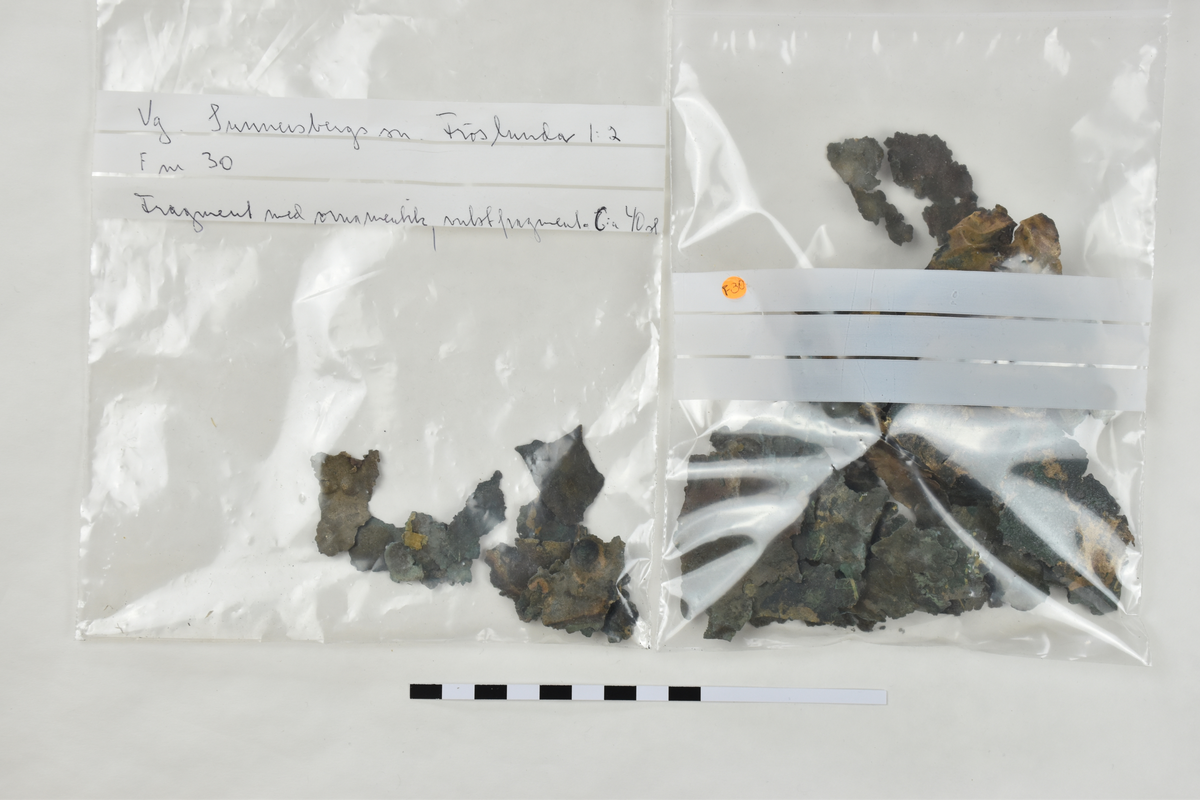 Sköldfragment, 44 st., med rester av ornamentik i form av vulster och bucklor.