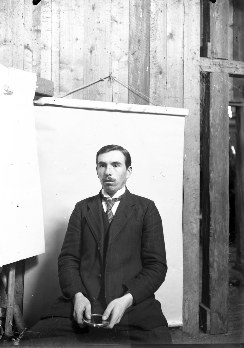 Selvportrett av fotografen Ole Romsdalen. Han holder på et lite speil 

Fotosamling etter fotograf og skogsarbeider Ole Romsdalen (f. 23.02.1893).