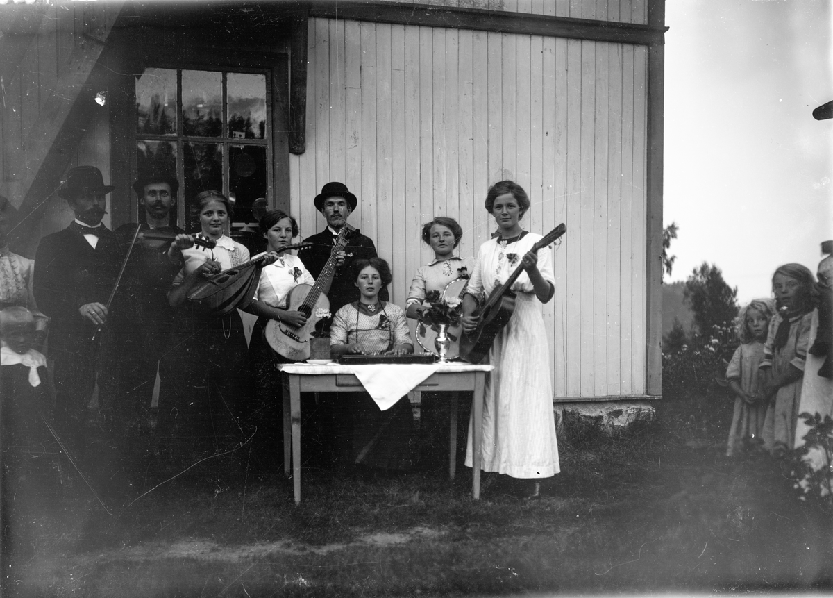 Gruppeportrett, sangforeningen på Soli i Oppdalen med gitarer, zither, orgel og mandolin. Ensamlet kan ha vært benyttet til vekkelsesmøter. 

Små barn kan sees til høyre 

Fra høyre: Paula Thormodsrød (Olsdatter, f. 1895), ukjent kvinne, Gunda Thormodsrød (1891) sittende, Johannes Grorud (bak) og Karoline Sølland. 

Fotosamling etter fotograf og skogsarbeider Ole Romsdalen (f. 23.02.1893).