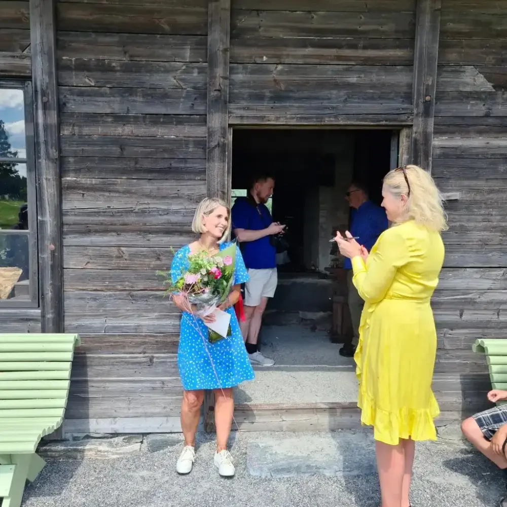Museumsleder Line Helstad og ordfører Kamilla Thue står utenfor Iversmia under åpningen av smia.