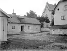 Gårdsinteriör från Stenhusgården i Linköping. I blickfånget krogen Amerika som efter en upprustning vid 1980-talet inrymmer kollektivverkstad för konstnärer som arbetar med grafik. Foto från omkring 1930 som tillskrivs Linköpingsfotografen Lars Fredrik Lovén.