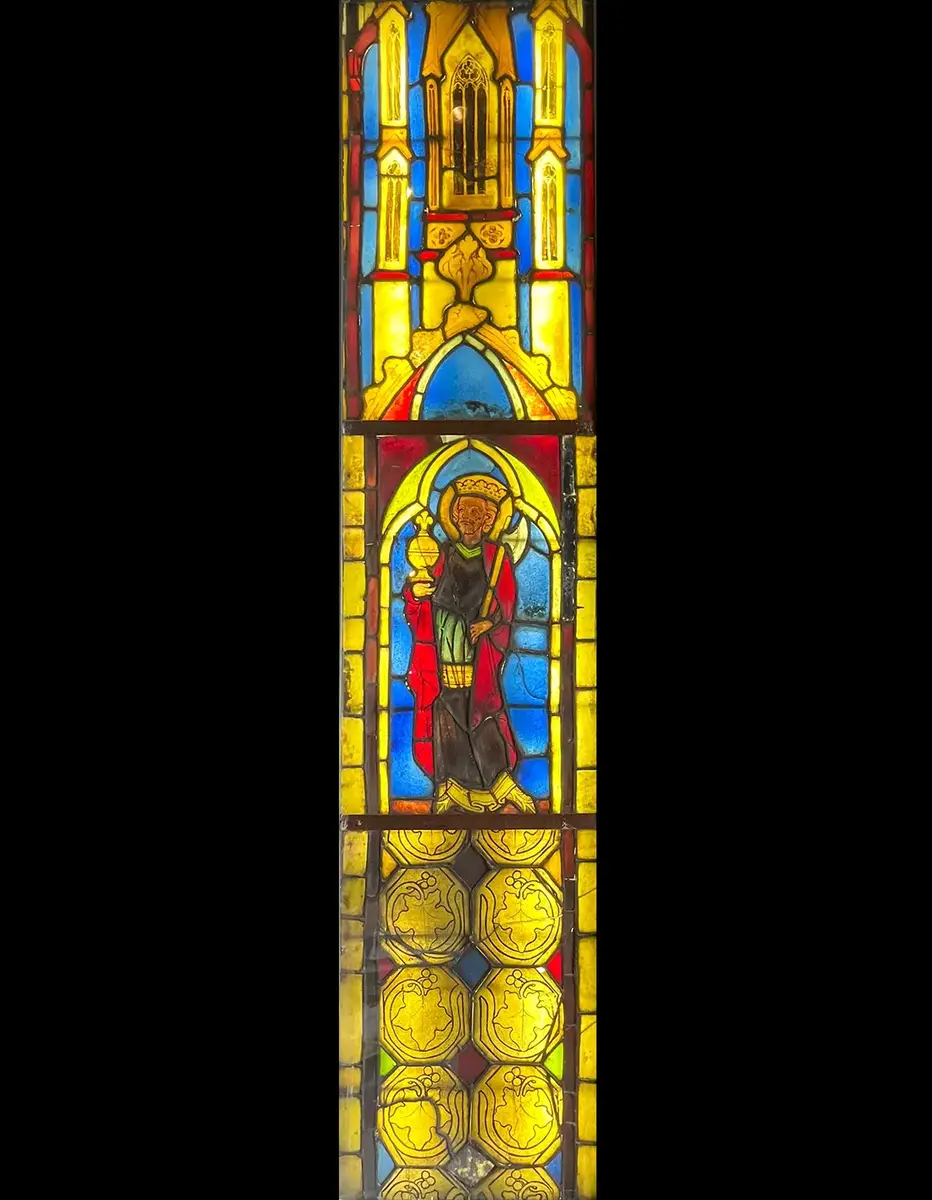 Målning på glas föreställande Sankt Olof med stridsyxa och kalk. Infattad i bly och försedd med träram.