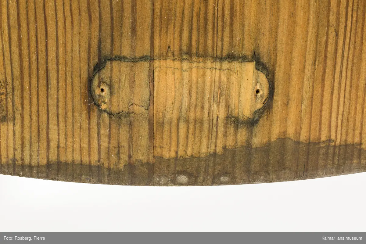 KLM 46378:5. Stol. Ingår i möbelserien "Sandhamn". Av furu med brunbetsad yta som senare även slipats. Skålad sits. Ryggen består av två ribbor fastsatta med smidda järnspikar, ena spikhuvudet saknas. Under stolssitsen märken efter en rektangulär metallbricka.