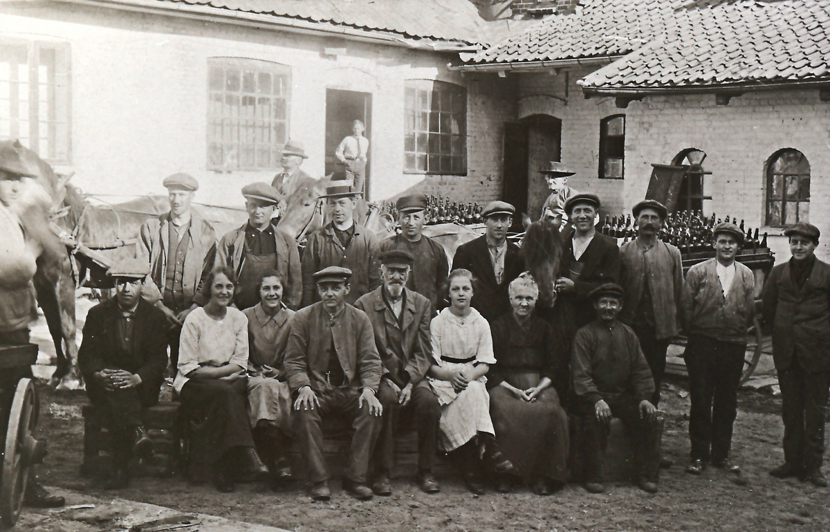 Ansatte ved Kongsberg bryggeri som lå i dagens Myntgt. 7 (gamle meieriet). Eier av bildet står til venstre foran hesten.
Deretter: Anton Olsen (1898-1977), Andreas Skarpås f.1898, Borger Andersen, Teodor Werp (1896-1974), Kristen Roe (1884-1977), ytterst til høyre Olaf Skarpås f.1900. Ølkjører Karl Plassen var også tilstede.
I fremste rekke ser vi bl. a. formannen Kristian Ruud f.1879 og fyrbøter Nordby. Formannens datter Dagny Elise (1905-1986). Ved hennes side gamle Kaja.