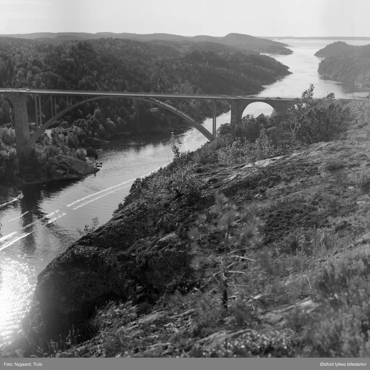Utsikt til den gamle Svinesundsbrua og Iddefjorden fra Hjelmkollen fort. Fortet anlagt 1905, videre utbygd under 2. verdenskrig. Fotografert ca. 1975.