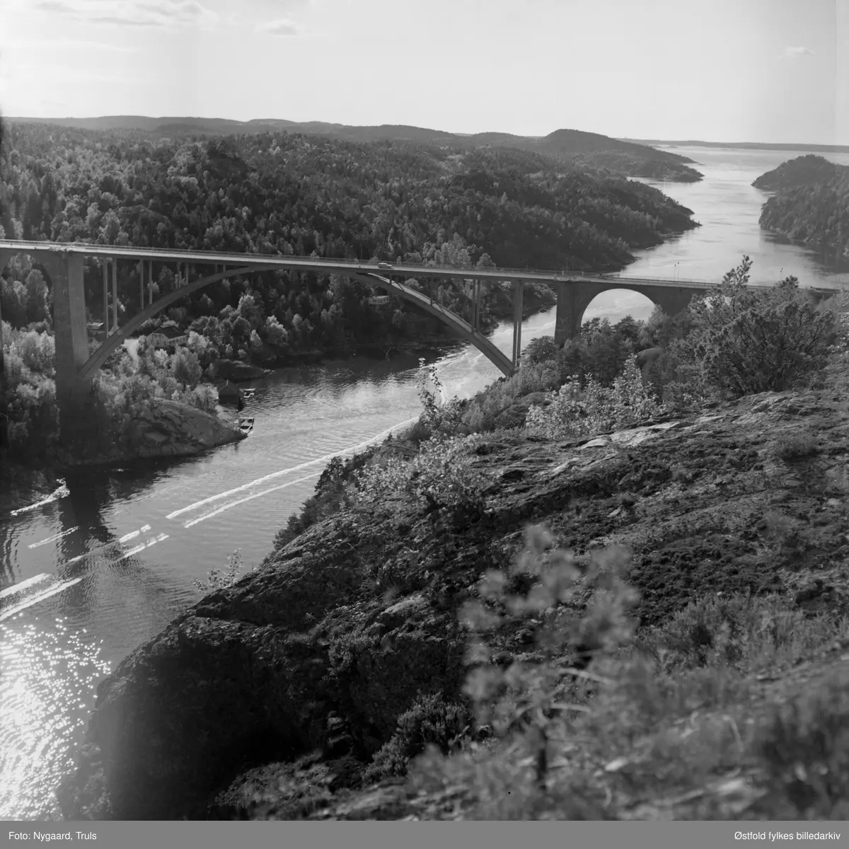 Utsikt til den gamle Svinesundsbrua og Iddefjorden fra Hjelmkollen fort. Fortet anlagt 1905, videre utbygd under 2. verdenskrig. Fotografert ca. 1975.