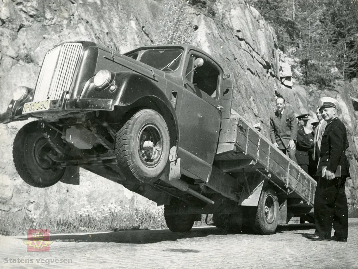 Bilsakkyndige kontrollerer lastebil Morris Commercial LC  fra perioden 1952-1960. 
Norsk Lastebilleksikon  "Lastebiler i Norge 1940-1990", av Asbjørn Rolseth.