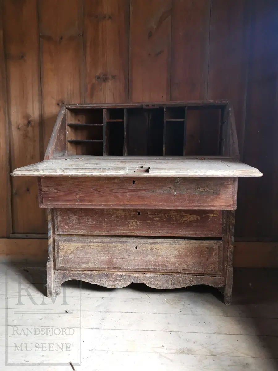 Med tre skuffer og nefellbar klaff. I klaffen er det rilledekor i to ruter-felt