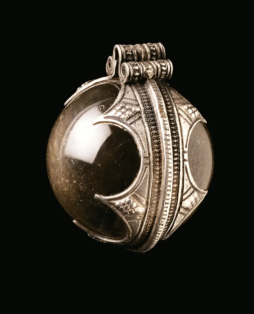 Klotrund kula av slipad bergkristall med omfattning av silver. Silvret dekorerat med inpunsat mönster samt upphängningsögla. 4,8 cm i diameter – den största silverinfattade kristallkula som påträffats i Norden.