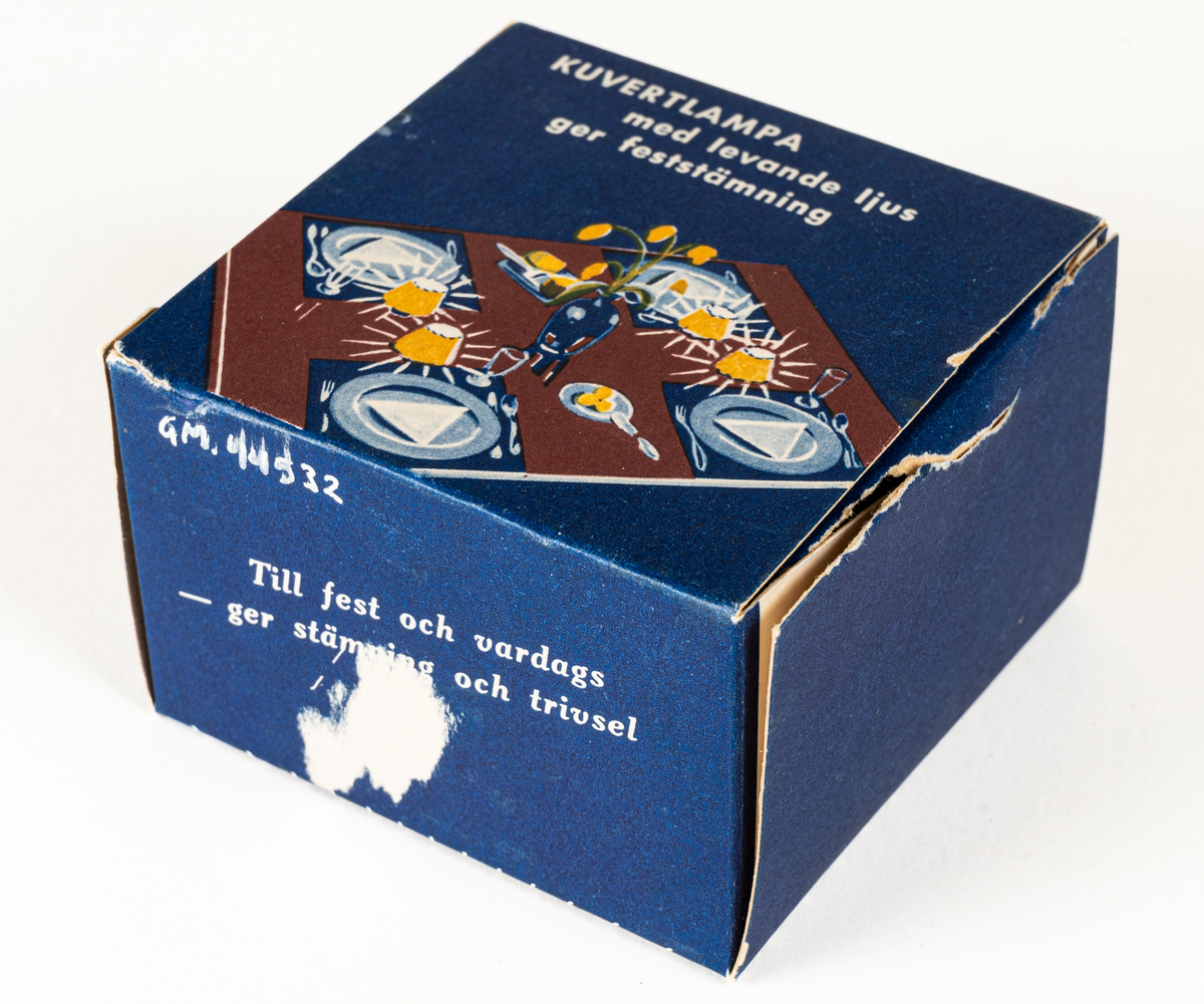 Ljuslykta för levande ljus, s.k. kuvertlykta. Röd fot med plats för ljus, vågig skärm, perforerad. Tillhörande blå originalask i papp.