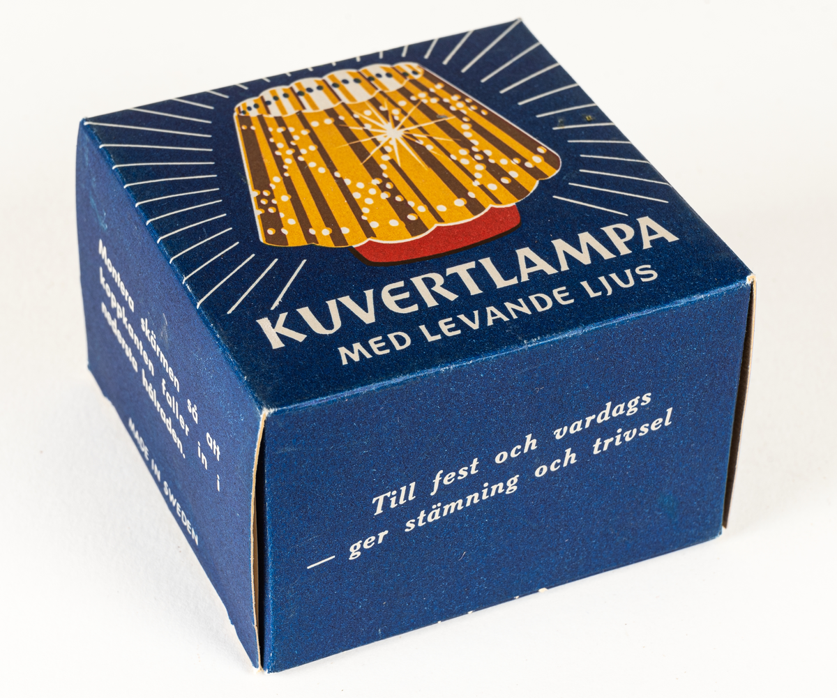 Ljuslykta för levande ljus, s.k. kuvertlykta. Röd fot med plats för ljus, vågig skärm, perforerad. Tillhörande blå originalask i papp.