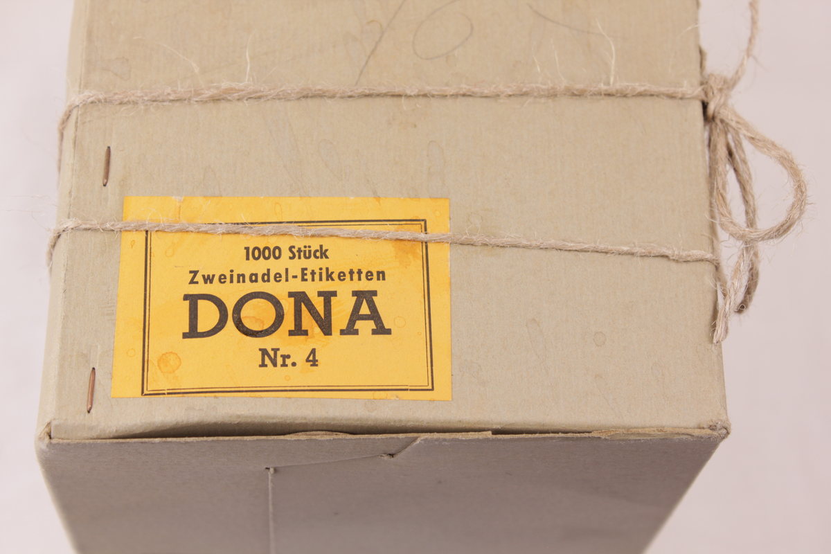 En eske med prisetiketter til hansker av typen Dona Nr. 4 "Zweinadel-Etiketten". Opprinnelig antall i esken var 1000.