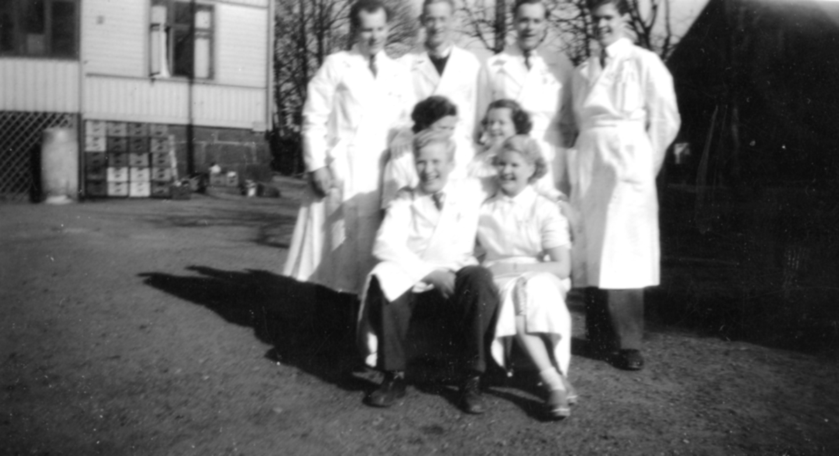 Lindgrens lanthandel på Gamla Riksvägen 42, 1940-tal. Personalen på åtta personer står utanför butiken, bl.a Rose Maj Benkel Ekström, Barbro, Erland Johansson och Pelle Lindgren. I bakgrunden ses butiken med några drickabackar ståendes utmed fasaden.