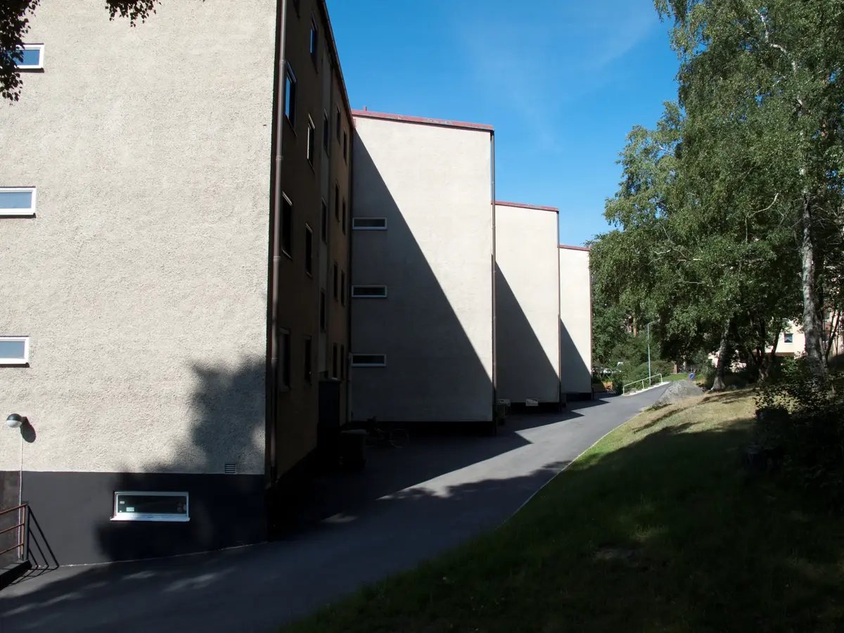 Putsade byggnadsvolymer med pulpettak.