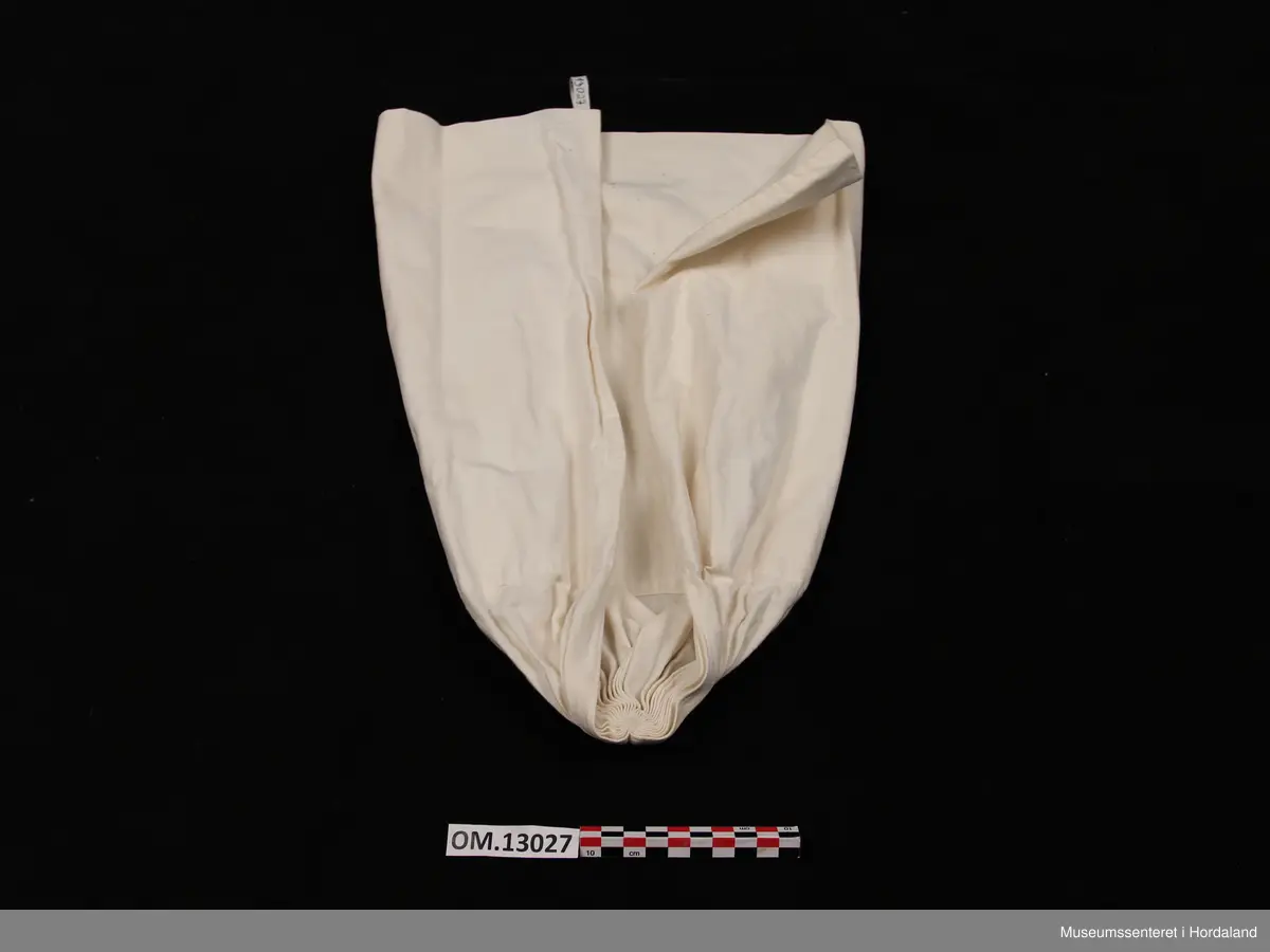 Kvithua er i bomull og har dobbelt stoff i største delen av hua, den delen av hua som skal festast rundt hovudet. Dette stoffstykket er avlangt og firkanta. I den andre enden (den som skal hanga ned på ryggen) er det enkelt stoff. Dette stykket er rynka saman som avslutning. Oppå samanrynkinga er det brodert eit lite rundt broderi med kvit tråd. Hua er open midt under.