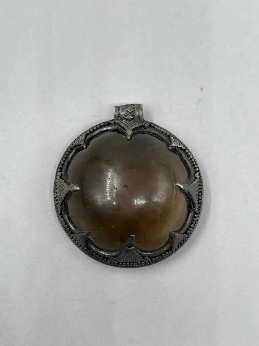 Hänge av bergkristall, halvsfärisk, gulaktig  kristall infattad i silver med upphägningsögla. Baksida i silver. 
Lämnades till museet tillsammans med "Fröjelkulan" GFC20139_1  
nyreg nov 2006/ml