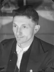 Portrett av en mann med en pin med bokstavene NKS(?).