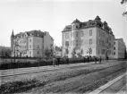 Parti av Linköping i en tid då fotografer ännu väckte uppståndelse. Bortom barnaskaran hade vid tiden ett nytt kvarter hastigt tillkommit i stadens södra utkant. Som S:t Kors kvarter 90-93 var det bokfört, efterhand namngavs det Ekoxen med hus utmed Klostergatan, Linnégatan och mot Trädgårdsföreningen bakom bebyggelsen.