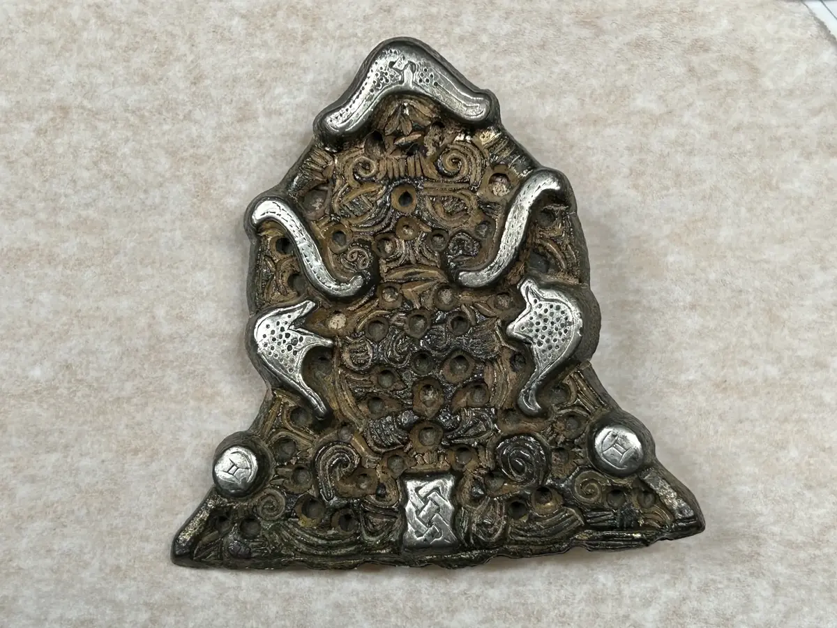 Vikingatida dräktspänne för kvinnodräkt. Spännet har dock ursprungligen varit den ena av ett par ändplattor till ett brett, sjuradigt kedjegarnityr. Kedjeplattan som ligger till grund för spännet har troligen tillverkats i början av 900-talet och senare samma århundrade gjorts om till spänne.

Gunildespännet är gjort av en dubbelsidig kedjeplatta. Framsidan är ett genombrutet arbete av förgylld brons med silverplätering. Ornamentiken består av bland annat räfflade band, flikar och bandringar och förhöjda silverpläterade fält - varav det övre i form av djurhuvuden med flygande panntofsar och därunder asymmetriska fält med punkterade ytor. Nertill på sidorna finns silverbelagda runda knoppar och i mitten en rektangulär bandflätning. Spännet avslutas överst med en silverpläterad "hatt", på vars baksida kedjeplattans hängögla är anbragt.

Basen med de sju kedjehålen sågades av när plattan gjordes om till spänne. Nålarrangemanget på baksidan består av en pålödd nålhållare och ett gångjärn som tagits från dosformiga eller djurhuvudformiga spännen.

Hittat vid hackning av konservärter i Torpåkern vid Gunilde i Sanda socken år 1927.