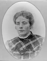 Portrett av en kvinne i en rutete bluse. Julie Larsen (Født 