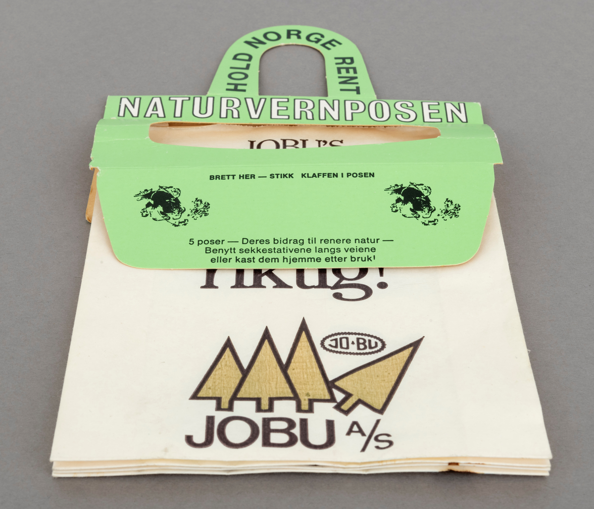 Fire papirposer , skal egentlig være fem, i en pappholder med oppheng der posene kan rives ut til bruk en og en. Posene er reklamemateriell fra motorsagprodusenten / salgsbedriften Jo-Bu i Drøbak i samarbeid med den ideelle organisasjonen "Hold Norge Rent". Posen kalles "Naturvernposen" og er produsert av firmaet Naturvernprodukter A/S.  Alle poser har Jo-Bus logo påtrykt.  Det er firmaet logo fra etter 1979 som er påtrykt posene. På den øverste posen, som har vært mest eksponert for sollys, har den grønne fargen  på de stilisrerte grantrærne falmet. 
På hver papirpose er en av Jo-Bu-firmaets sagvettregler påtrykt. Disse reglene lanserte firmaet i forbindelse med "Sagvett-kampanjen" i 1981: 
Den første posen mangler.
Pose nr 2: JOBU'S Sagvettregel nr. 2:   Bruk sagen riktig!
Pose nr. 3: JOBU'S Sagvettregel nr. 3:  Vær riktig kledd!
Pose nr. 4: JOBU'S Sagvettregel nr. 4:  Ta vare på sagen din! 
Pose nr. 5: JOBU'S Sagvettregel nr. 5:  Tenk før du sager!

På selve poseholderen ses Kjell Aukrust figur Ludvig, som var maskot for ryddekampanjen Hold Norge Rent. [Etter informasjon på hjemmesiden til Hold Norge Rent per 15.11.2023, ble denne aksjonen egentlig ble avluttet i 1977,  men det kan tyde på at Jo-Bu koblet seg til den ideelle organisasjonen med Sagvett-kampanjen i 1981.]