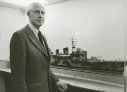 Man bredvid modell av jagaren VISBY utställd på Sjöhistorisk