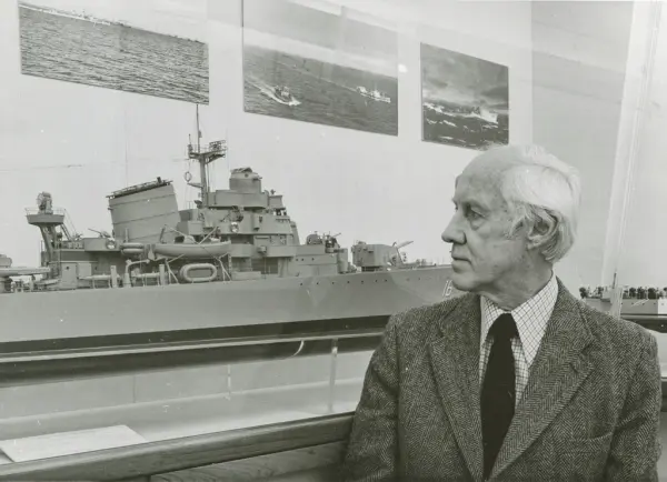 Man bredvid modell av jagaren ÖLAND utställd på Sjöhistorisk