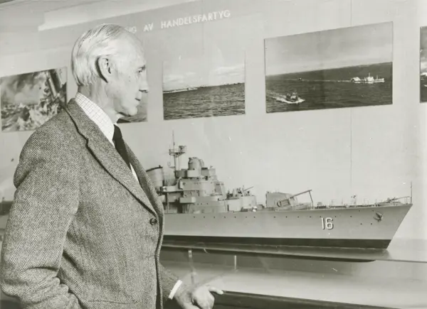 Man bredvid modell av jagaren ÖLAND utställd på Sjöhistorisk