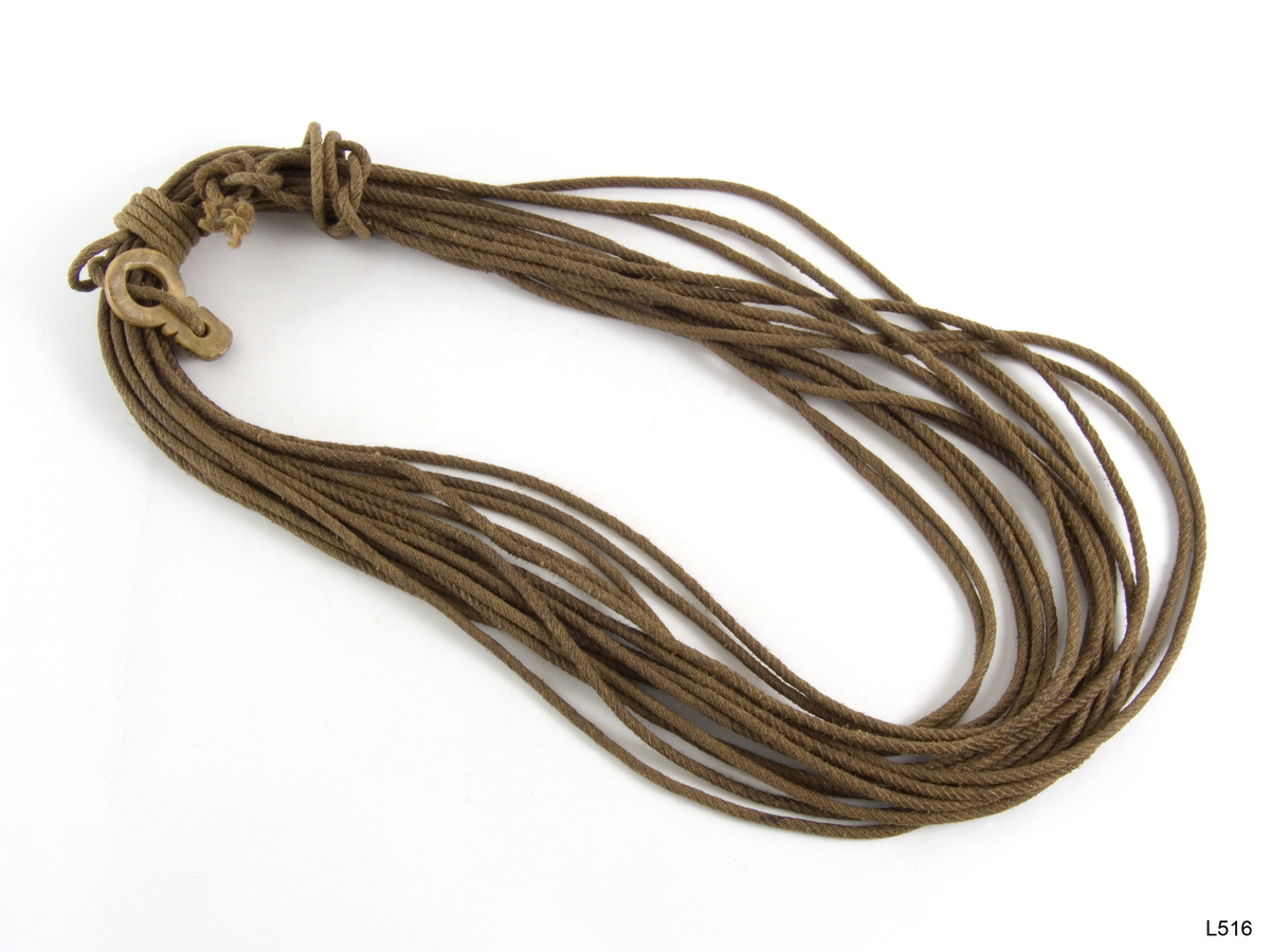 Lasso med hornring. Selve lassoen er 22,75 m lang . Ringen er laga av Aslak Mjenna , Čoavddatmohkki ved Sjusjavre . Den er uten ornament. Lassoen er brukt av en Kautokeino same . Innkjøpt hos Nils Biti , Sjusjavre av Vrn. våren 1952.