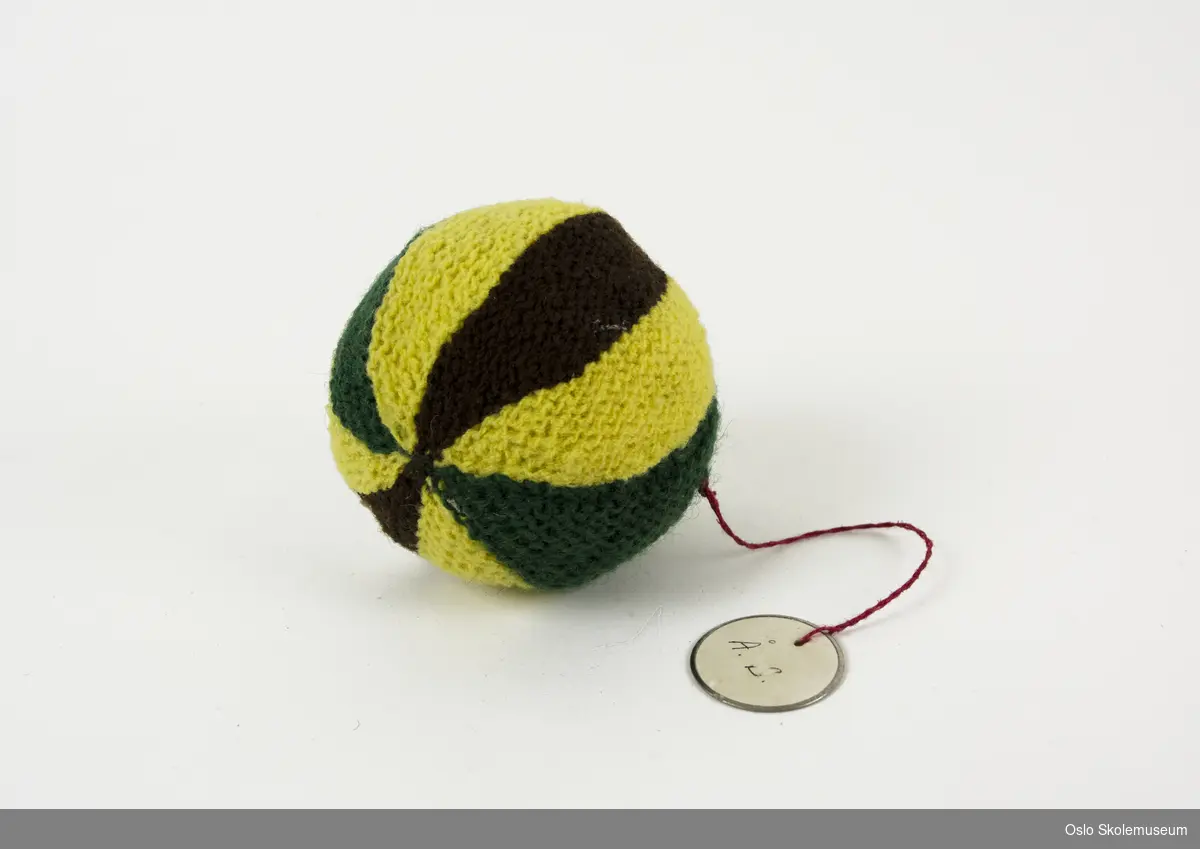 Ball strikket av grønt, brunt og gult garn,