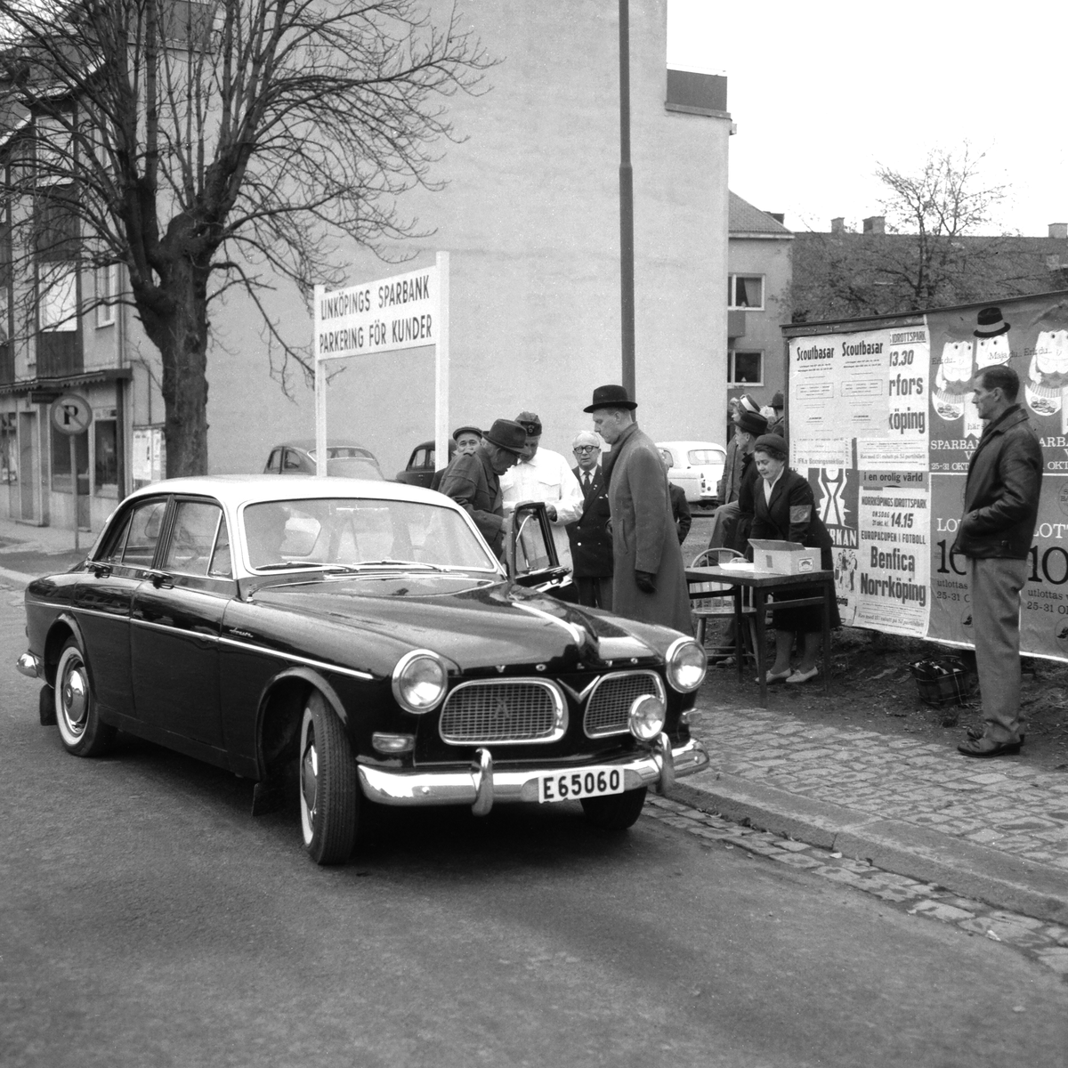 Fotografens liggare ger inga tydliga besked för motivet men att vi bevittnar ett inslag av bilrally i samband med Sparbankens "Sparbanksvecka" står klart. Här vad vi får förmoda vara tävlingens startfålla på Ågatan i höjd med kvarteret Braxen.