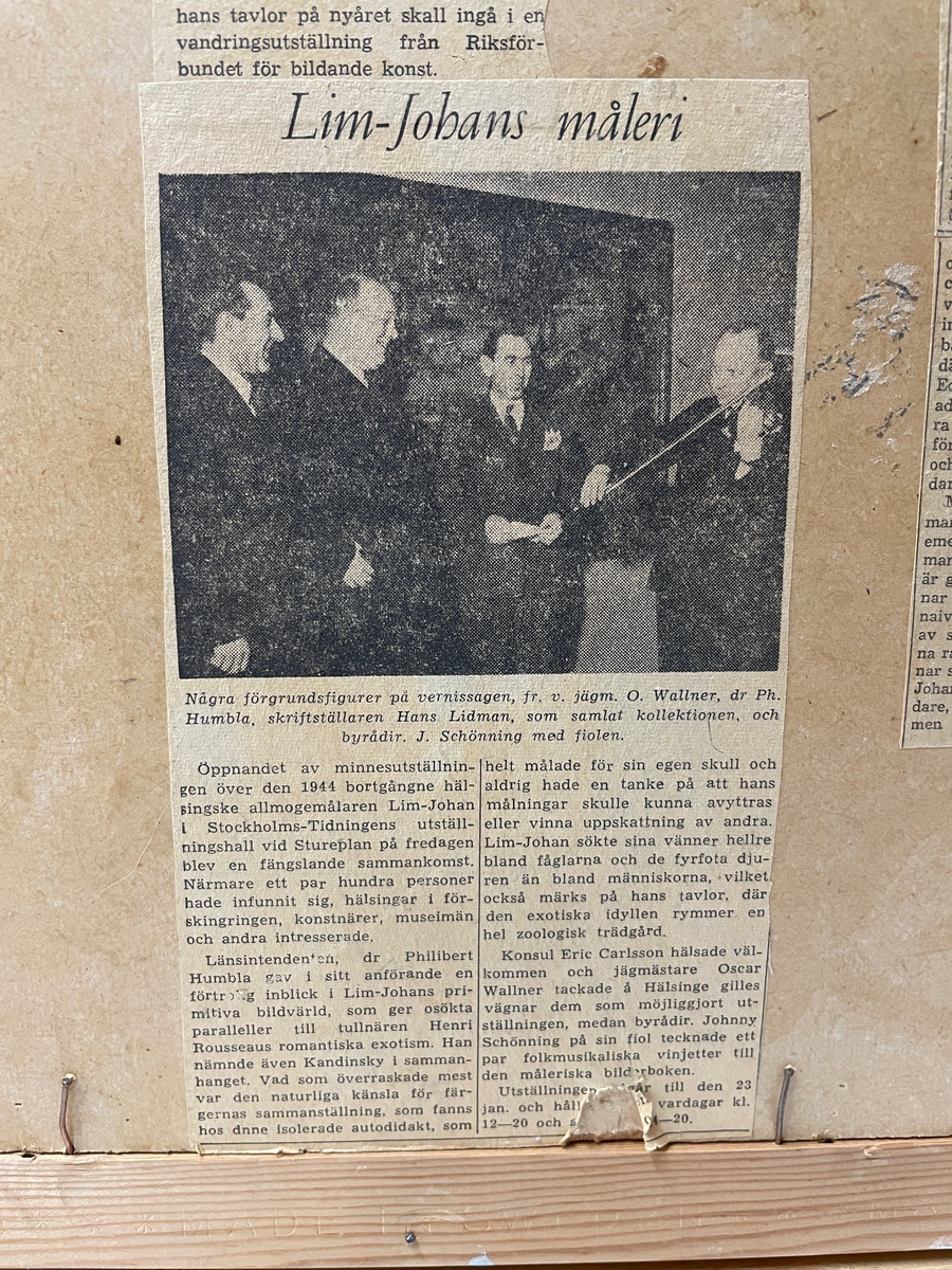 Oljemålning på kartong av Lim-Johan (Johan Erik Olsson) "Ångbåt vid åmynning", 1914-1923. 
Två män metar vid en bro över en åmynning. I bakgrunden en ångbåt, över vilken en stor klöverblomma reser sig som ett träd. På baksidan en mängd gamla tidningsklipp.