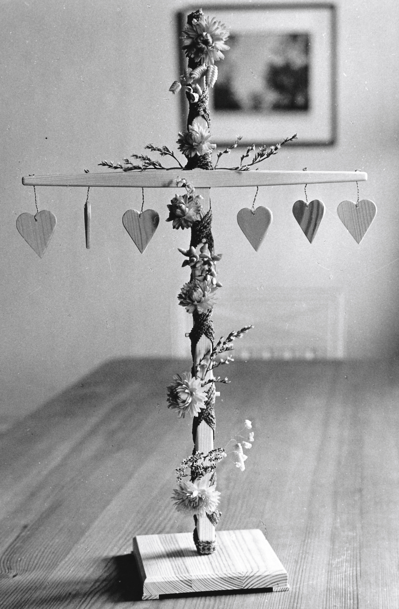 Majstång/midsommarstång/bordsdekoration i trä med hängande trähjärtan och mässing i ringarna.