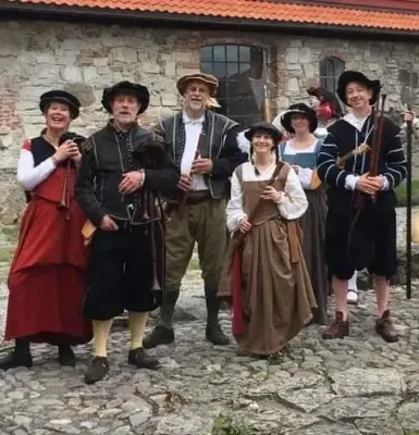 Tre damer og tre menn kledd i renessanse drakter i svart, rødt, brunt og blått. De holder instrumenter. Sekkepiper, lutt og skalmeie.