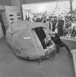 Två museipedagoger visar en räddningsflotte i utställningen 