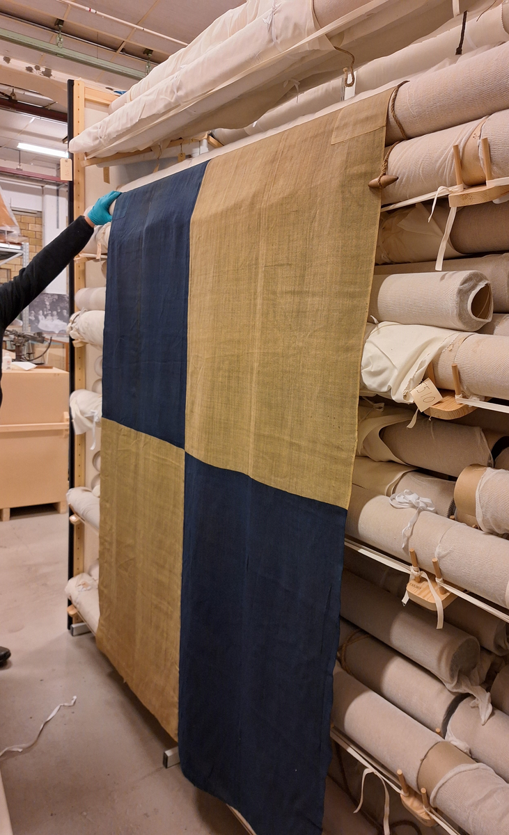 Flagga av bomull, fyra fält, det övre inre fältet blått, det undre gult, det yttre fälten vice versa. Splitsad strop med spolformad låsknapp av trä. Bokstaven L, märkt med svart färg på övre delen av stående liket. (L enligt Commercial code fr 1857)

Enligt C. E. Stenius, Handbok för sjöfarande, Åbo 1874, se sid 380:
Viktiga afstånds-signaler.
"För att på ett hastigt sätt äfven kunna signalera meddelanden av särdeles vigt, har man gifvit dessa aderton signaltecken utom deras alfabetiska också en annan betydelse, nemligen: återgifvande af hela meningar och för att tillkännagifva, att de hissade signalerna just hafva denna betydelse, hissas kulan ensamt efter hvarje signal. Till de mest vigtiga afstånds-signalerna räknas dock de fyra sammansättningarna med två tecken."...
L. betecknar: Behöfver lots. Kan jag få någon?