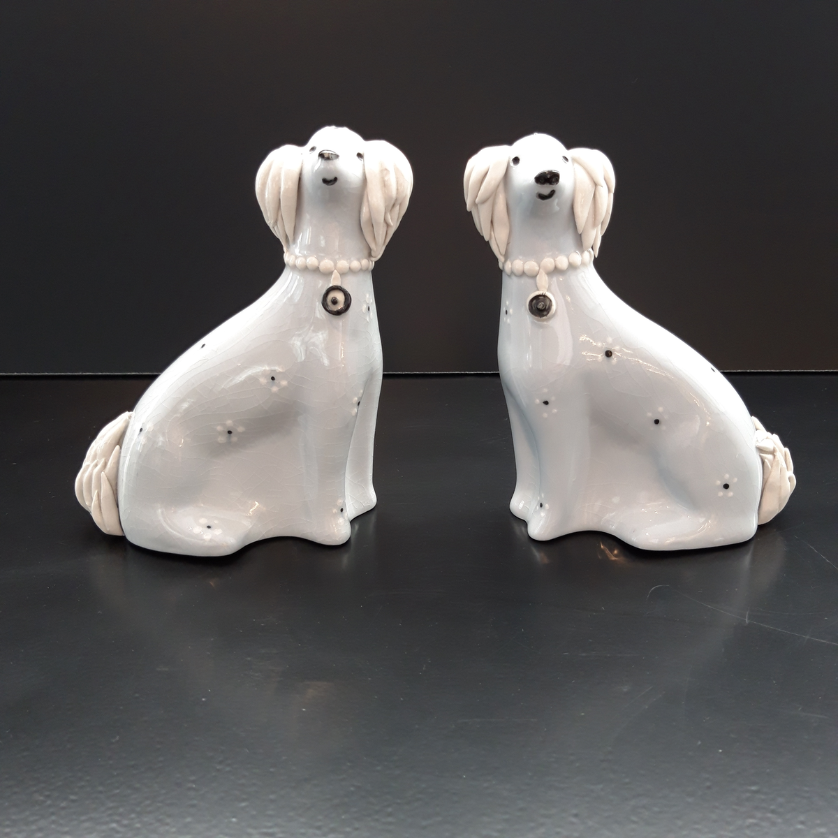 Figuriner, ett par. Två ljusblåa hundar i flintgods "Pang" och "Dang". Handmålad dekor med detaljer i relief. Tillverkade vid Gefle Porslinsfabrik 1955-1957, formgivna av Dotothy Clough.