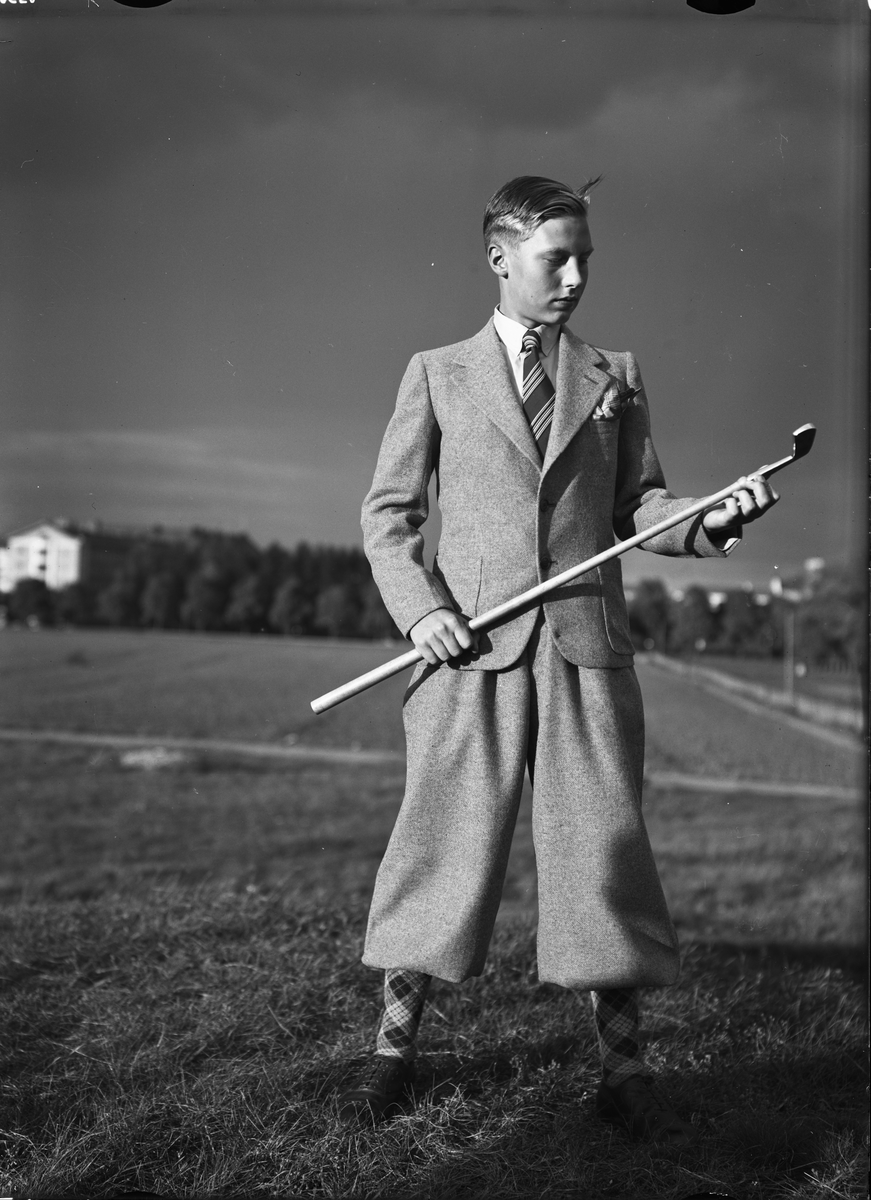 En pojke står och håller i en golfklubba, Uppsala 1936