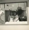 Två kvinnor står inuti tobaksmonopolets utställning vid jubileumsutställningen i Härnösand 1935.