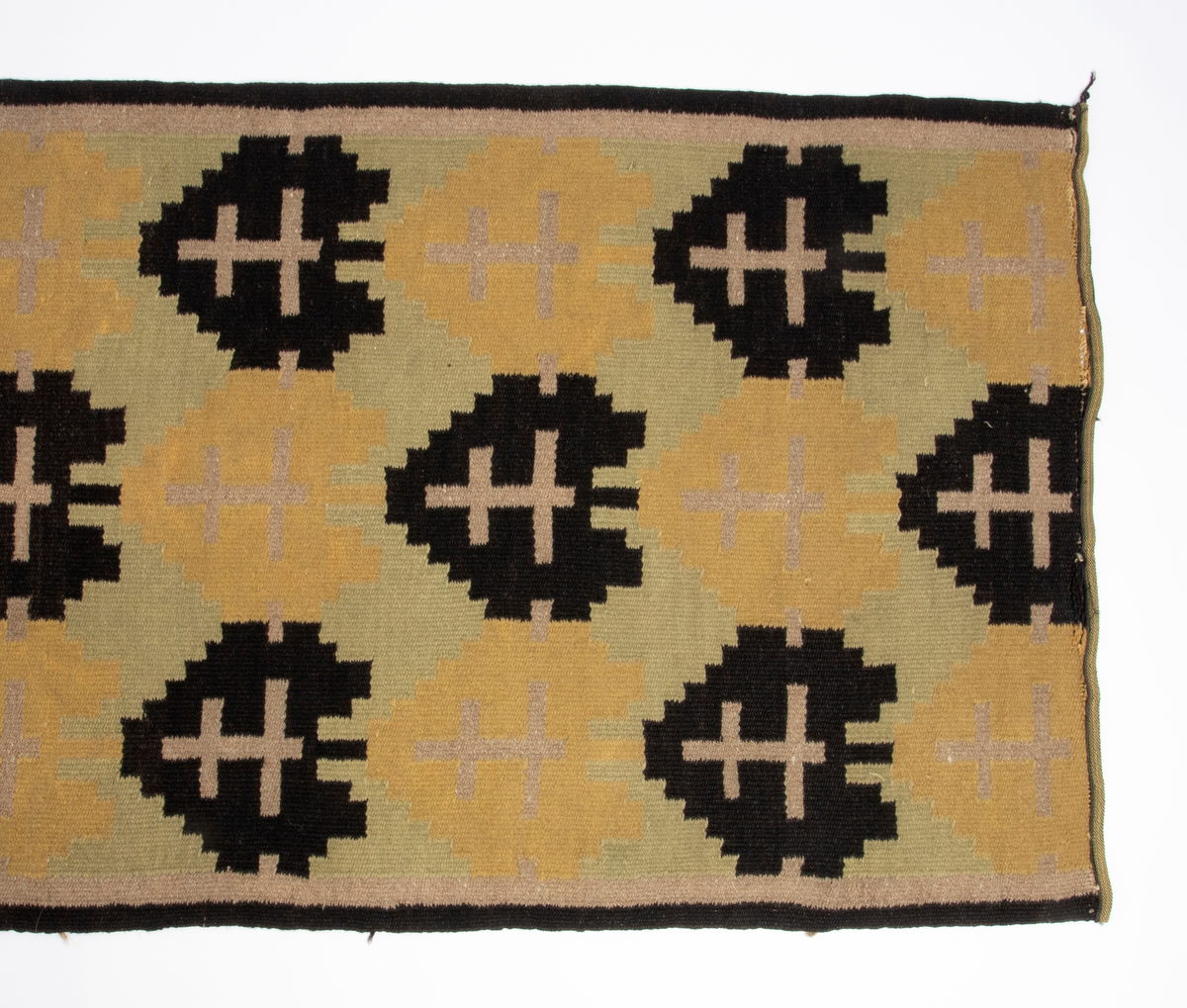 Rektangulær gulvløper i rutevevteknikk i tykt ullgarn. Innslag i svart, gult, grønt og beige på grov hamprenning. Motivet er et stilisert tre eller "hjerte" i svart og ett i gult; gjentatt regelmessig langs hele løperen.
