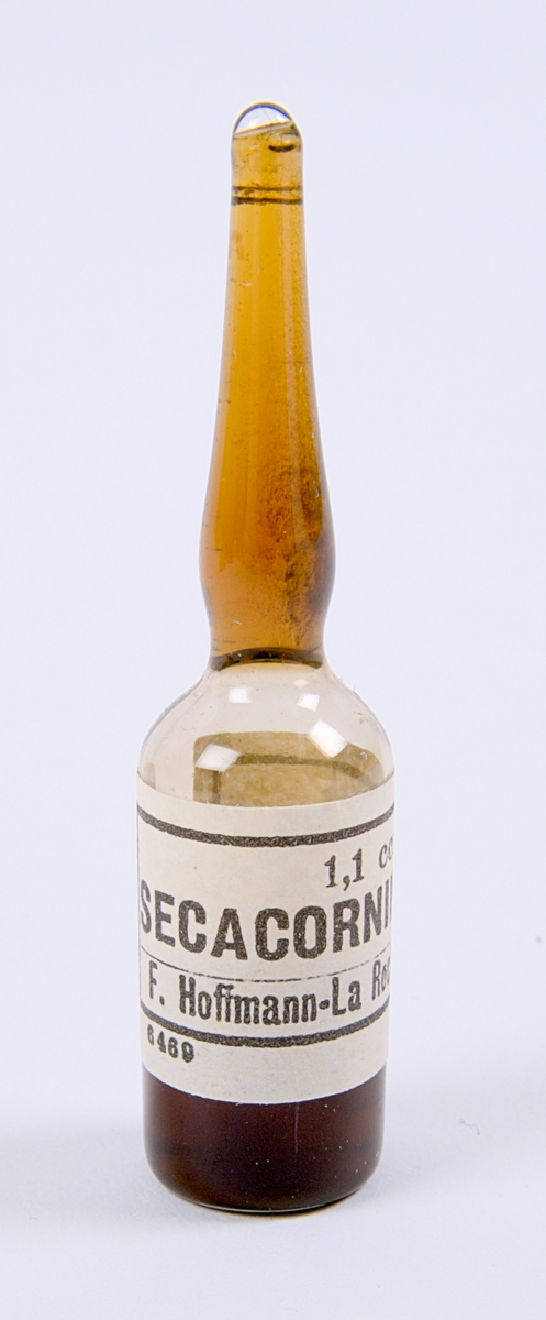 Medicinförpackning av papp. På förpackningen ett fastklistrat recept. Förpackning innehåller två stycken ampuller av läkemedlet Secacornin.