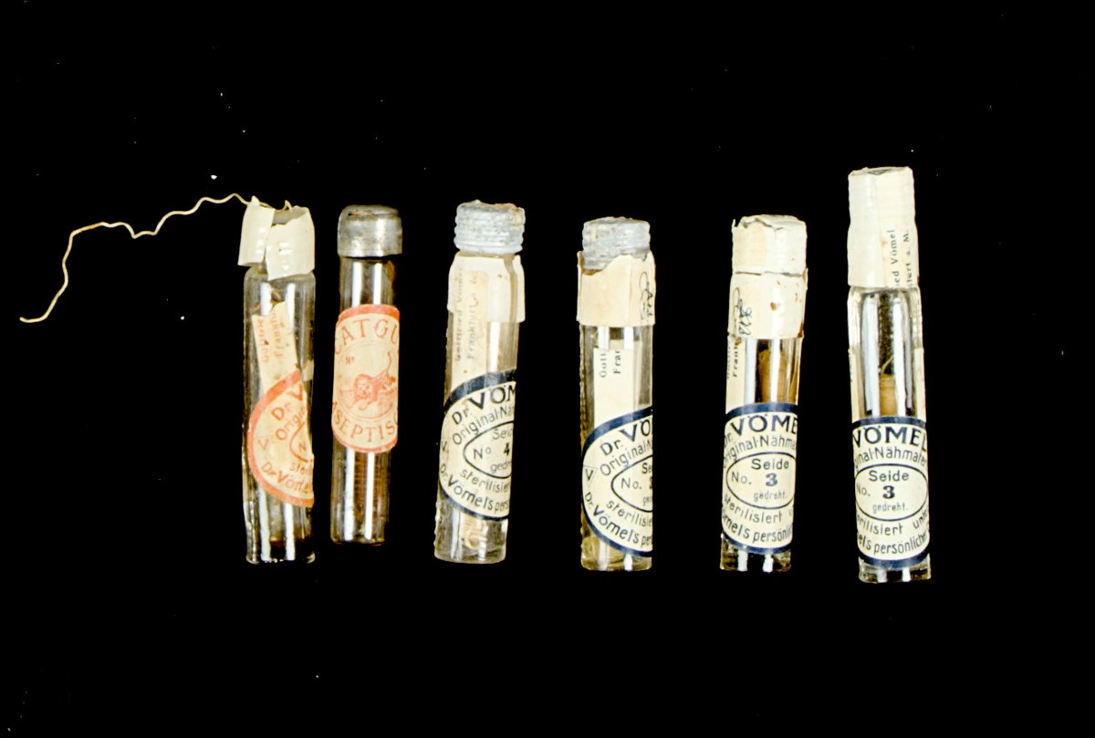 Sutursilke, samling. 

Flaska A). Längd:70mm Bredd: 13mm. Text på flaskan: Dr.VOMEL´S NÄHMATERIAL 

Flaska B). Längd: 70mm.Bredd:12mm.

Flaska C). Längd: 72mm. Bredd: 13mm. Text på flaskan: Dr.VOMEL´S NÄHMATERIAL 

Flaska D). Längd: 72mm. Bredd: 13mm. Text på flaskan: Dr.VOMEL´S NÄHMATERIAL 

Flaska E). Längd: 72mm. Bredd: 13mm. Text på flaskan: Dr.VOMEL´S NÄHMATERIAL 

Flaska F). Längd: 72mm. Bredd: 13mm. Text på flaskan: Dr.VOMEL´S NÄHMATERIAL