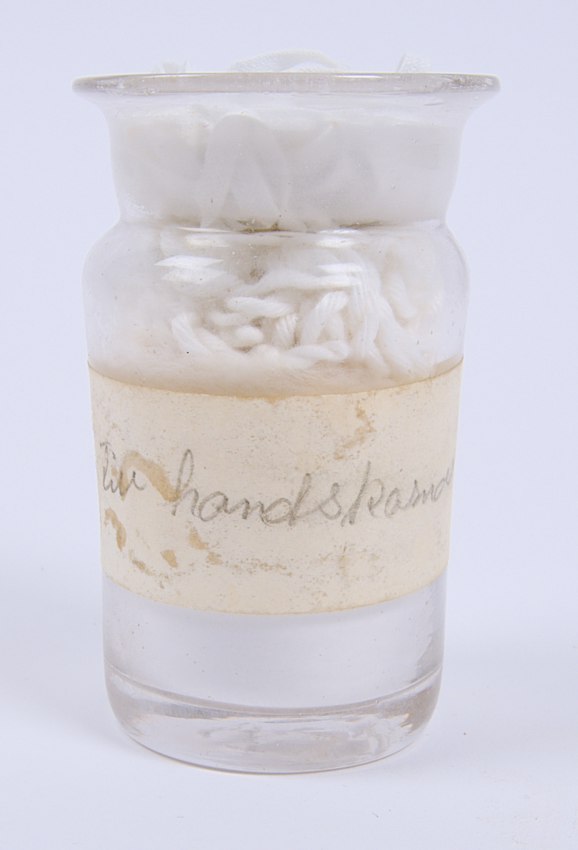 Glasburk innehållande "Talk för handskar", enligt den handskrivna etiketten som sitter på burken.