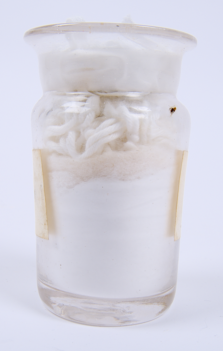 Glasburk innehållande "Talk för handskar", enligt den handskrivna etiketten som sitter på burken.